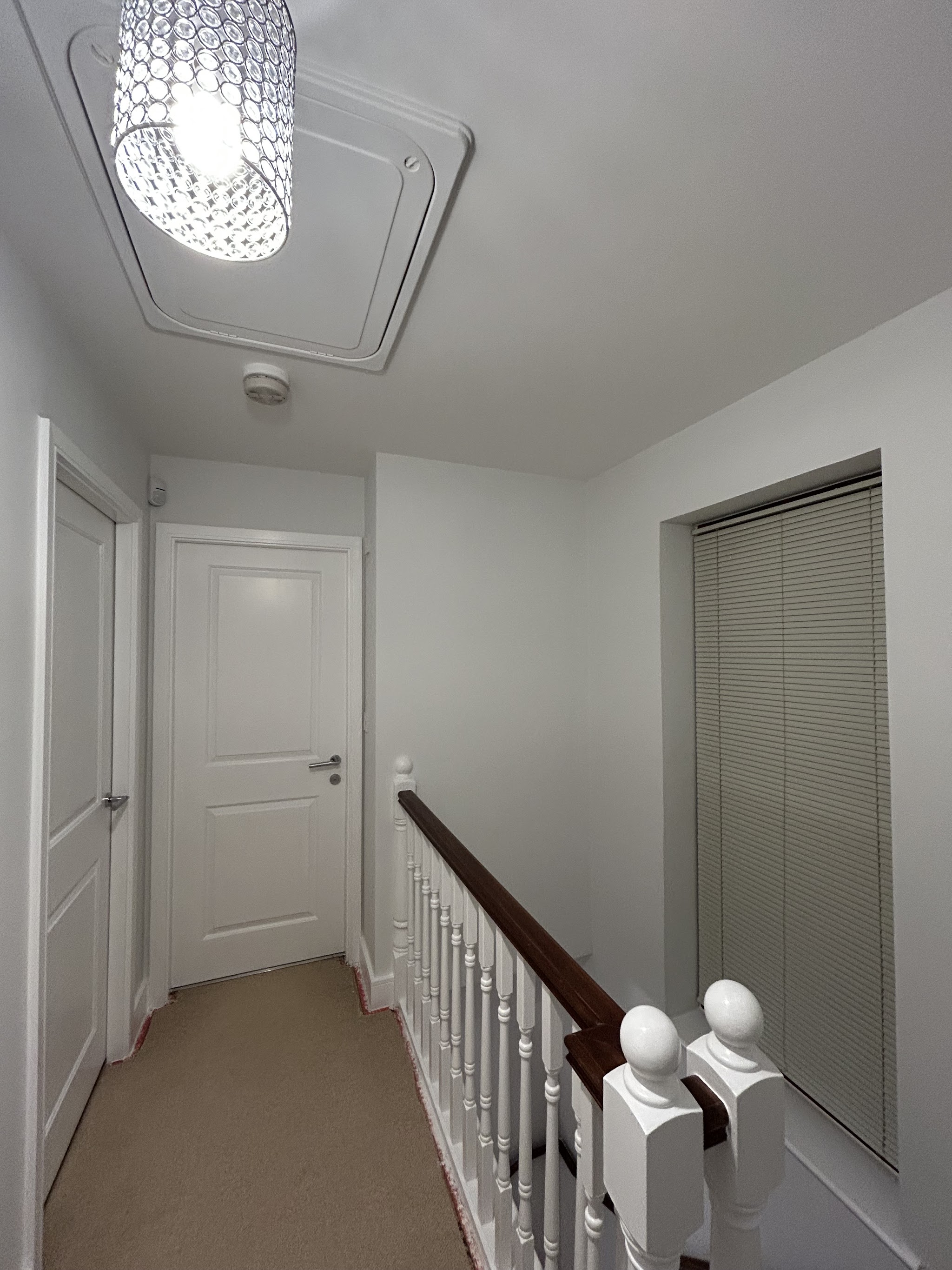 Freshly painted landing with white doors and spindles