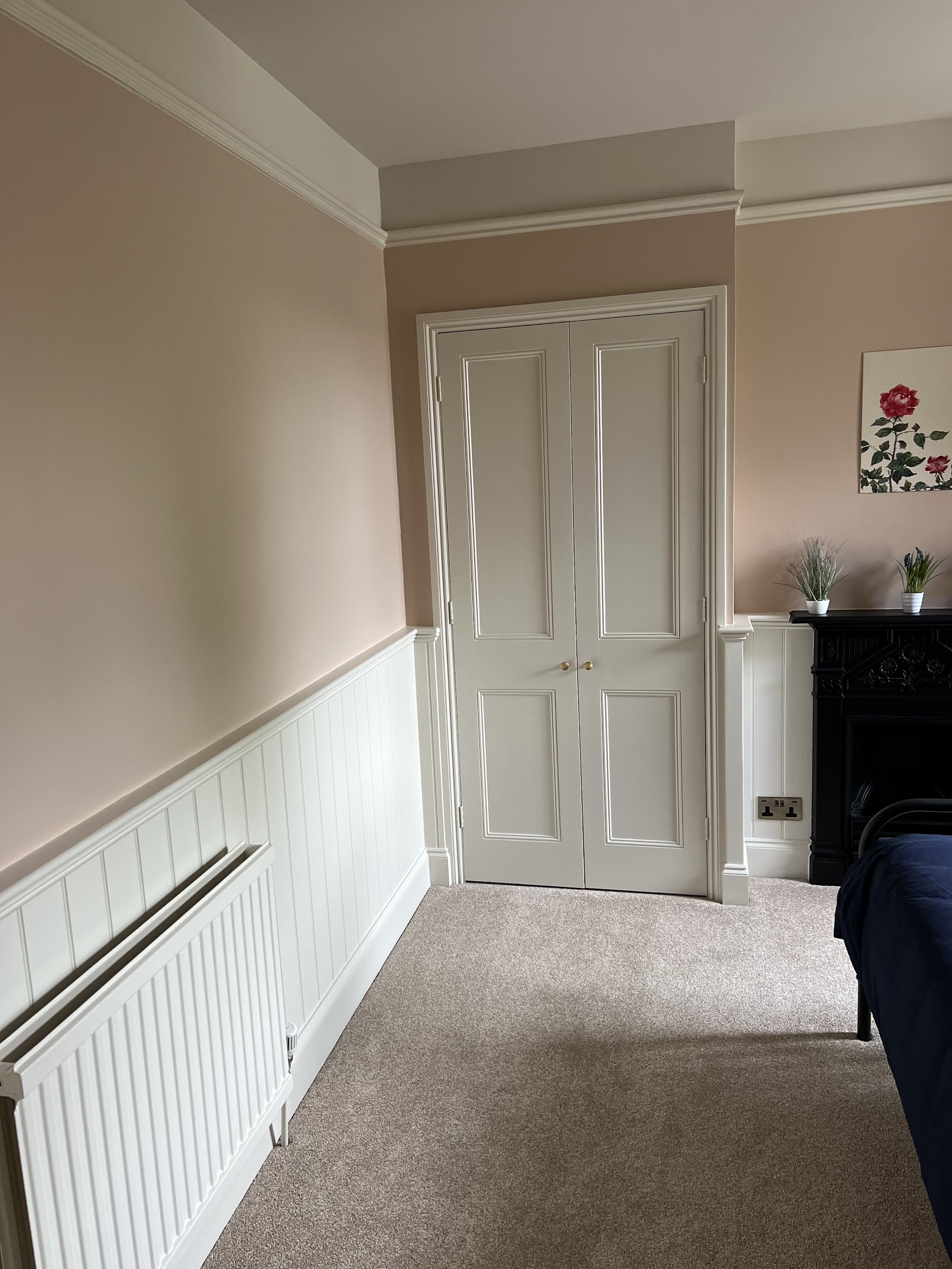 Victorian bedroom with painted panelling in soft pink and white