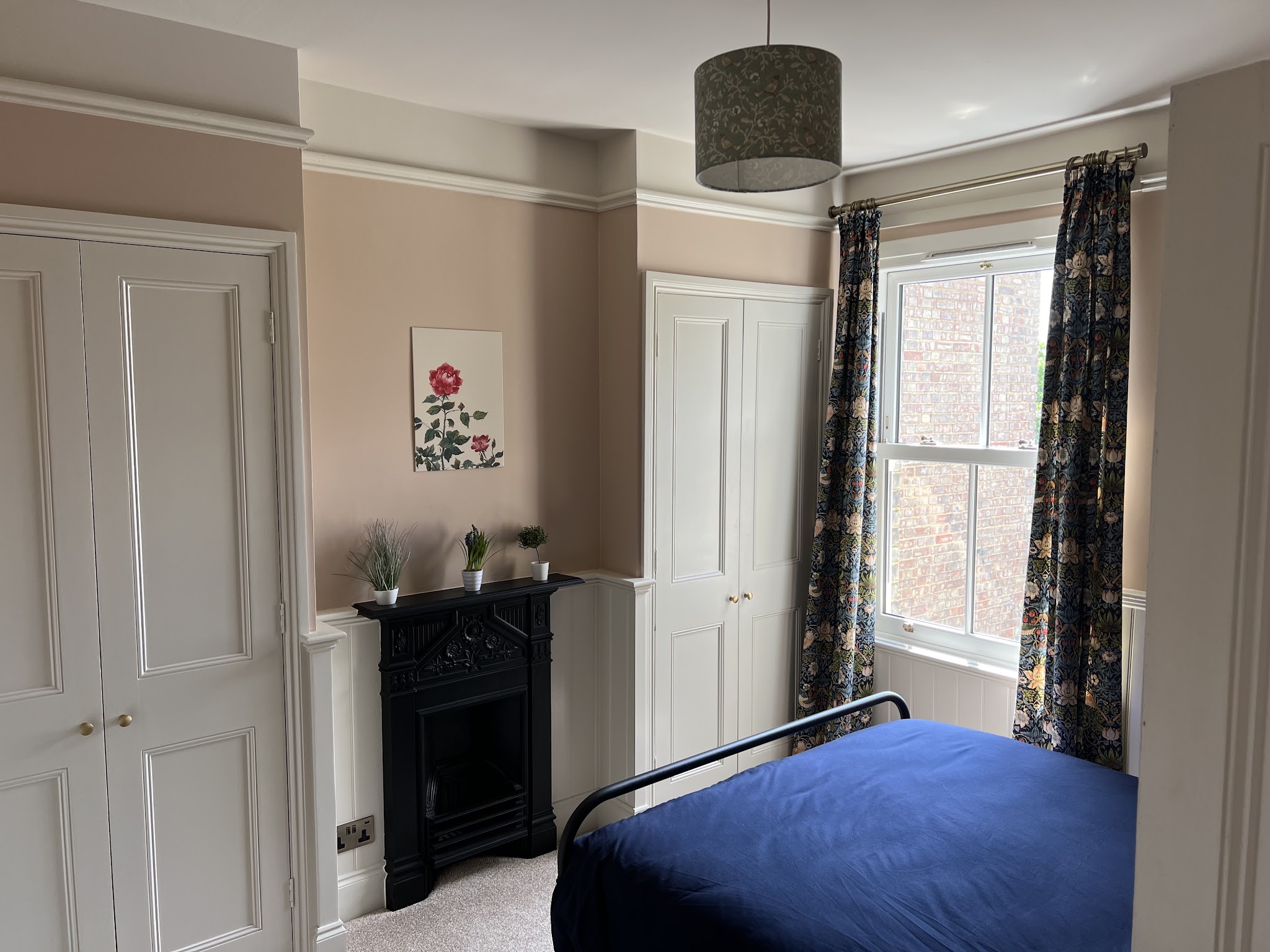 Bedroom with fitted cupboards and panelling in soft pink and white