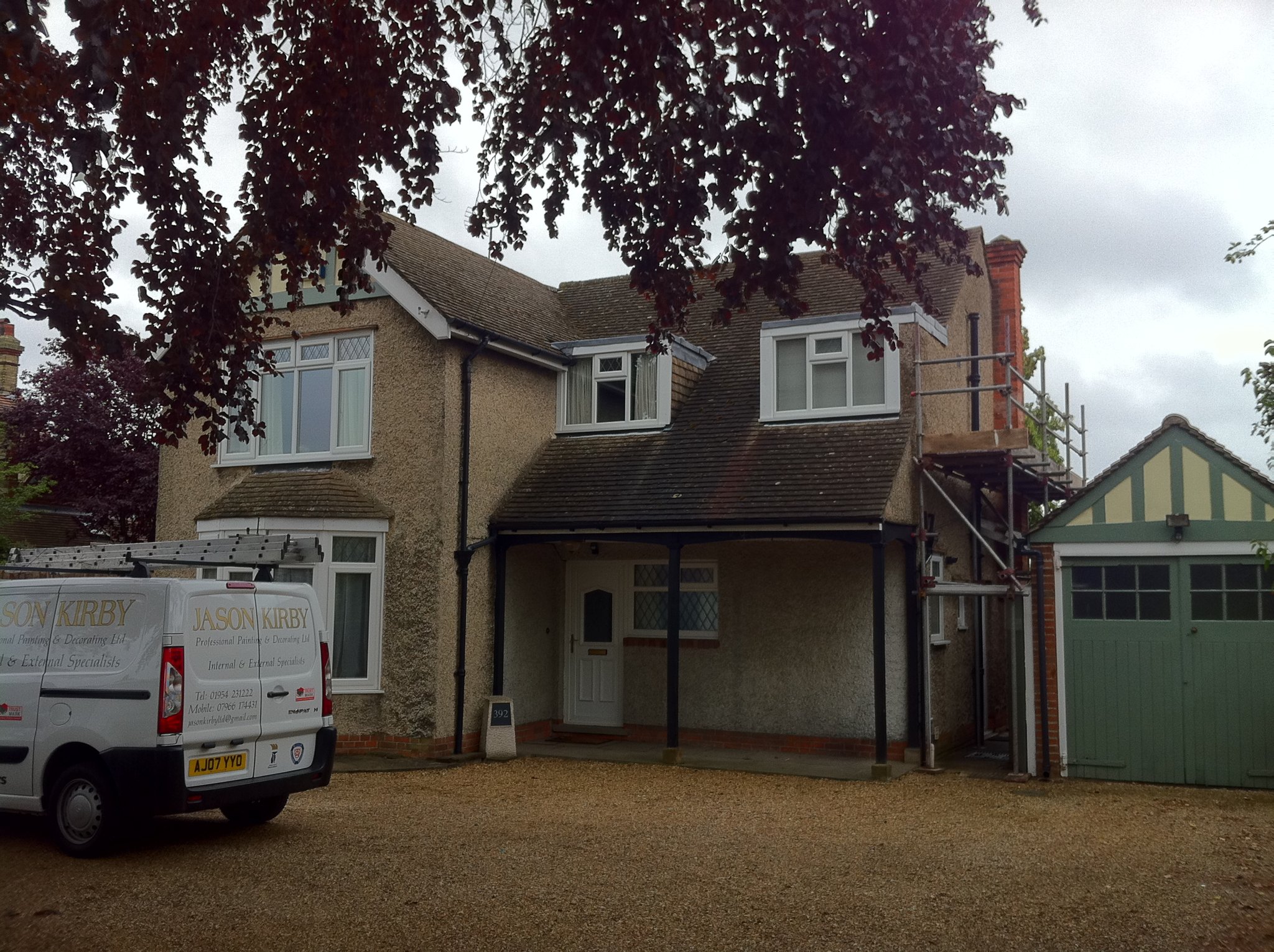 House exterior during work, with company van on the drive