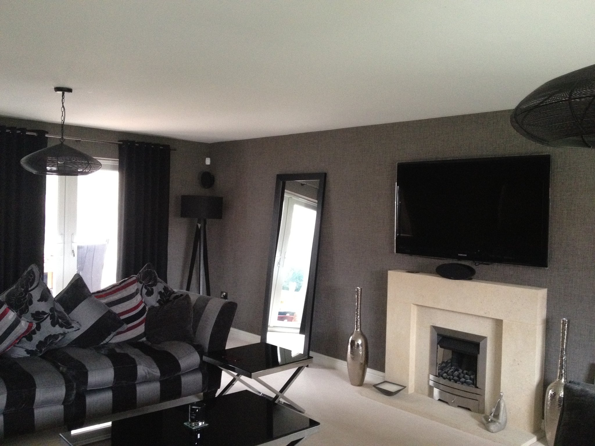 Living room in a dark textured designer wallpaper