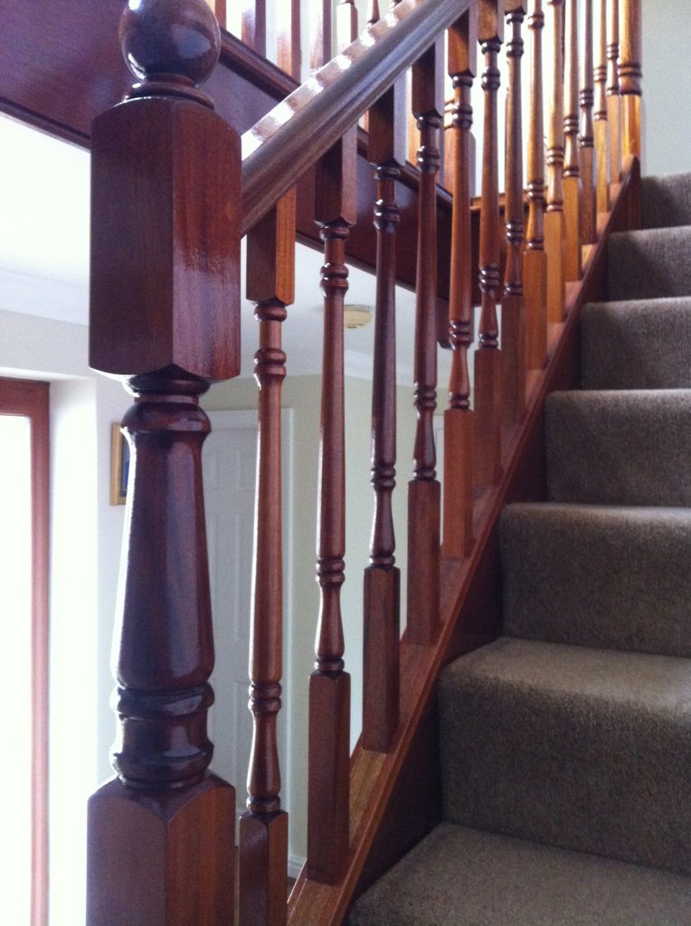 Mahogany handrail and turned spindles on a staircase