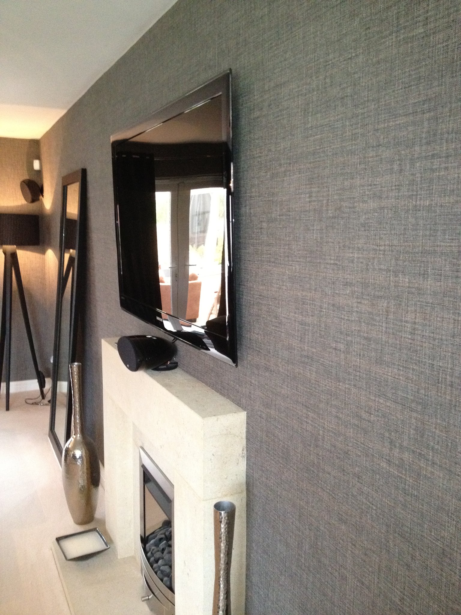 Grasscloth feature wall behind a fireplace