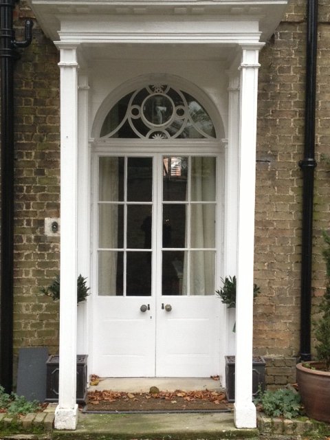 Georgian doorway with columns and fanlight painted white