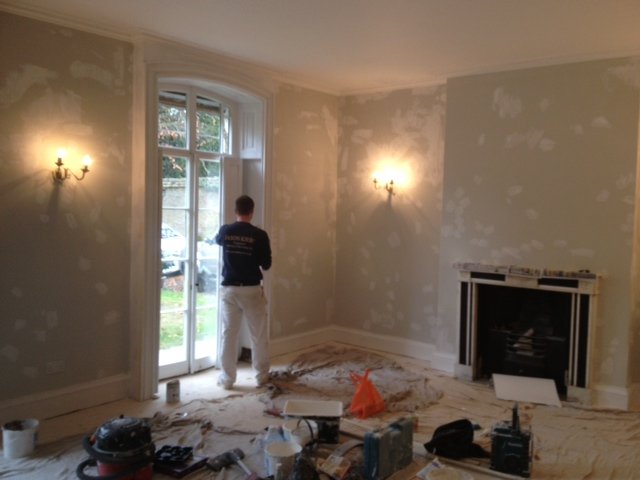 Decorator at work in a period room with fireplace