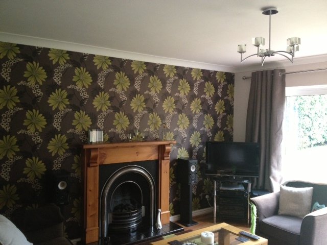 Floral wallpaper chimney breast with cast iron fireplace