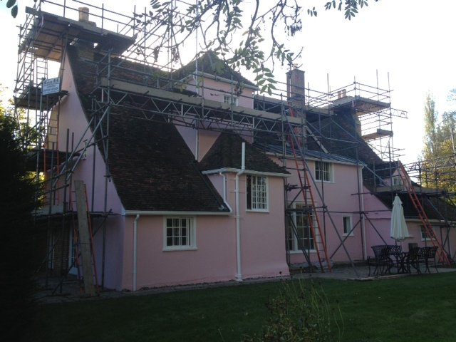 Pink cottage with scaffolding up for repainting