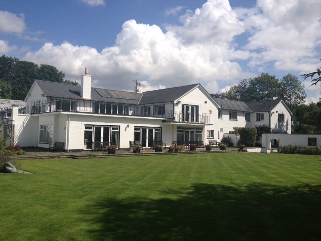 Large white painted house across a lawn
