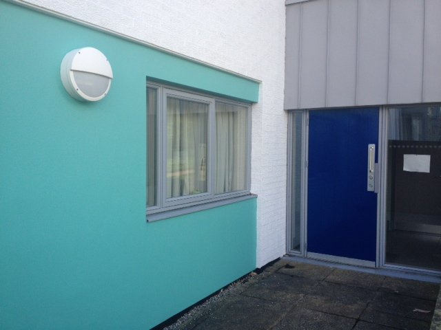 Contemporary apartment block exterior in white and teal