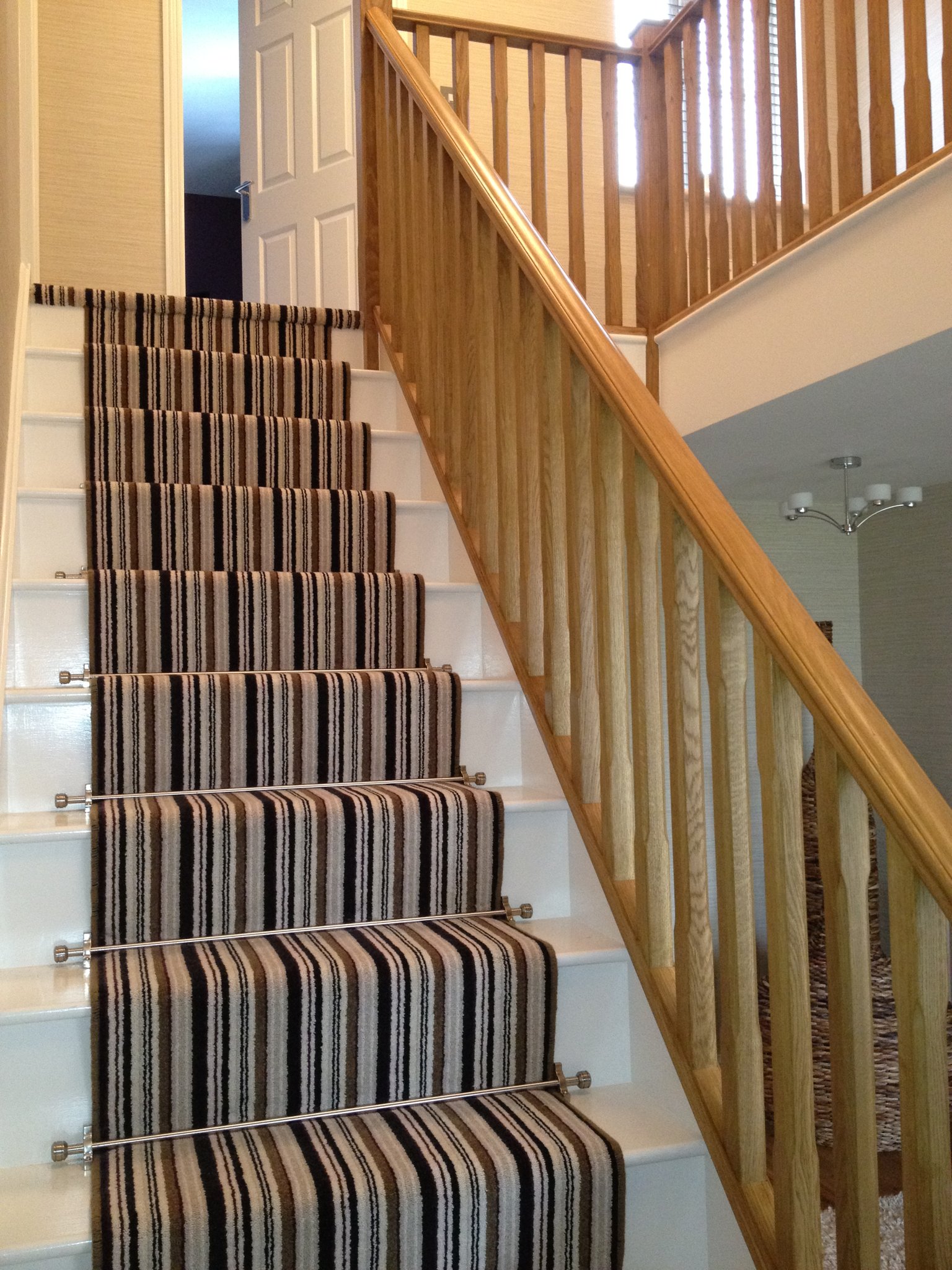Oak and white staircase with striped carpet