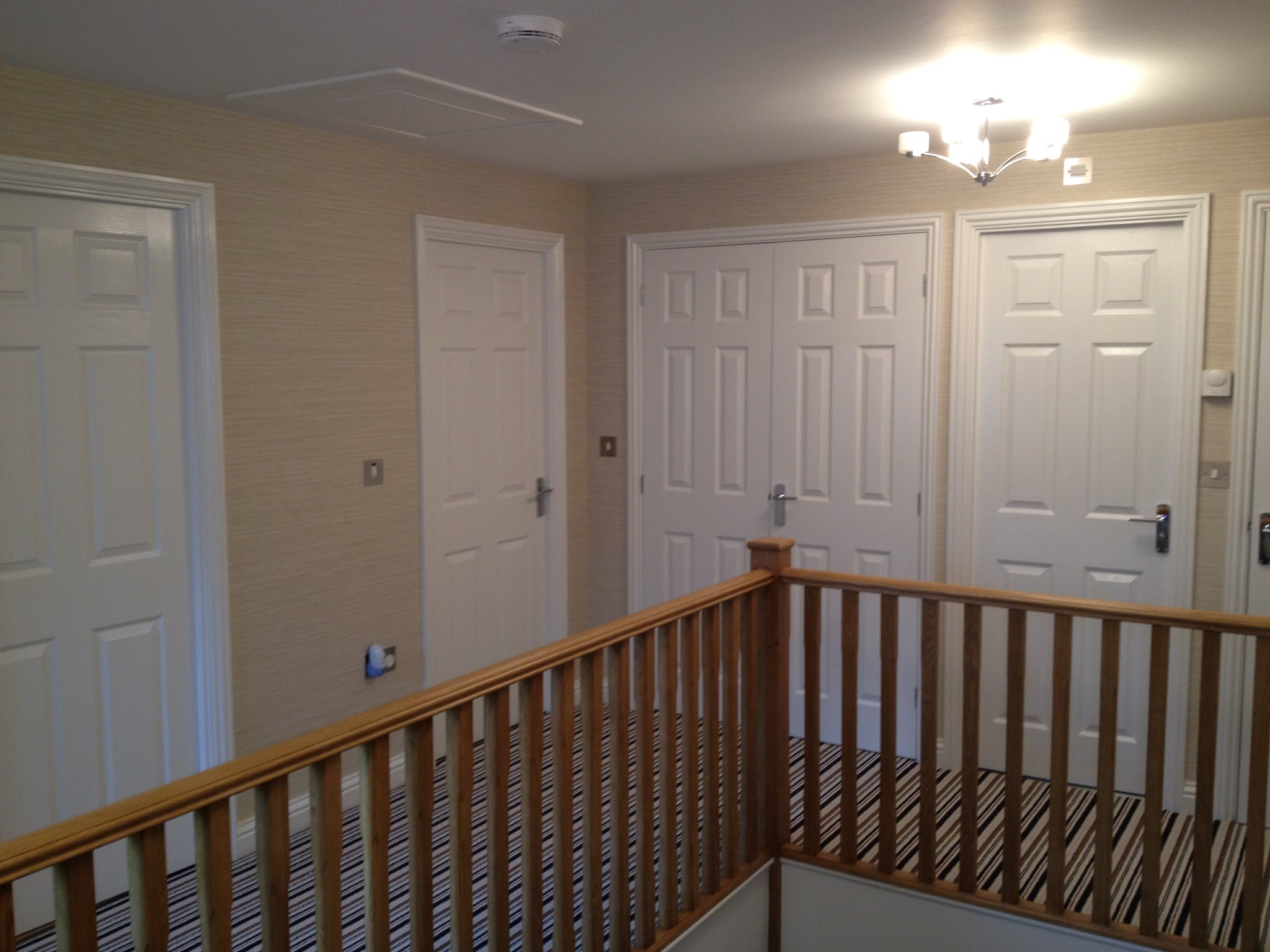 Landing with oak balustrade and textured wallpaper