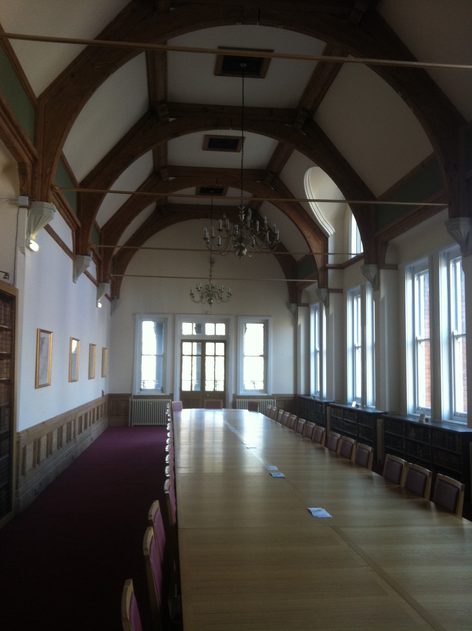 Long panelled hall with a hammer beam roof and chandeliers